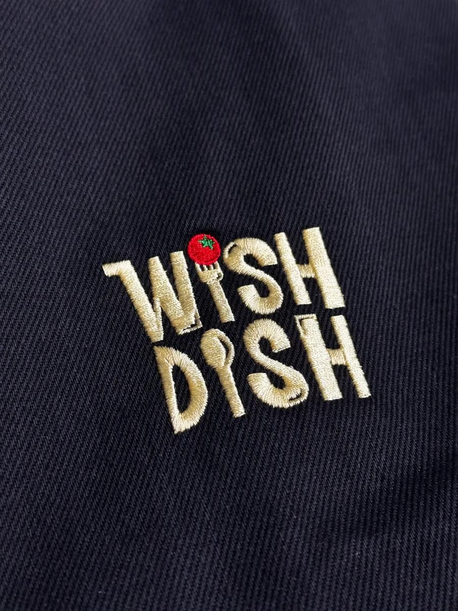 Gold embroidered logo on navy fabric, close-up