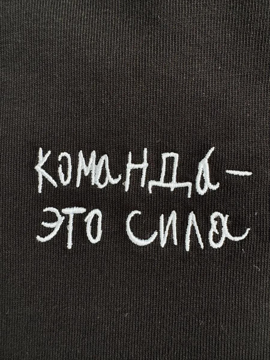 White embroidered handwritten lettering on black fabric
