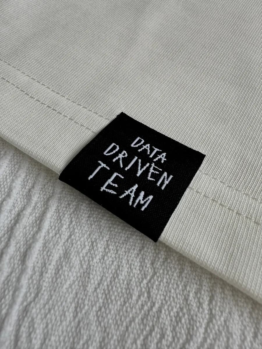 Black woven label with team lettering on a garment