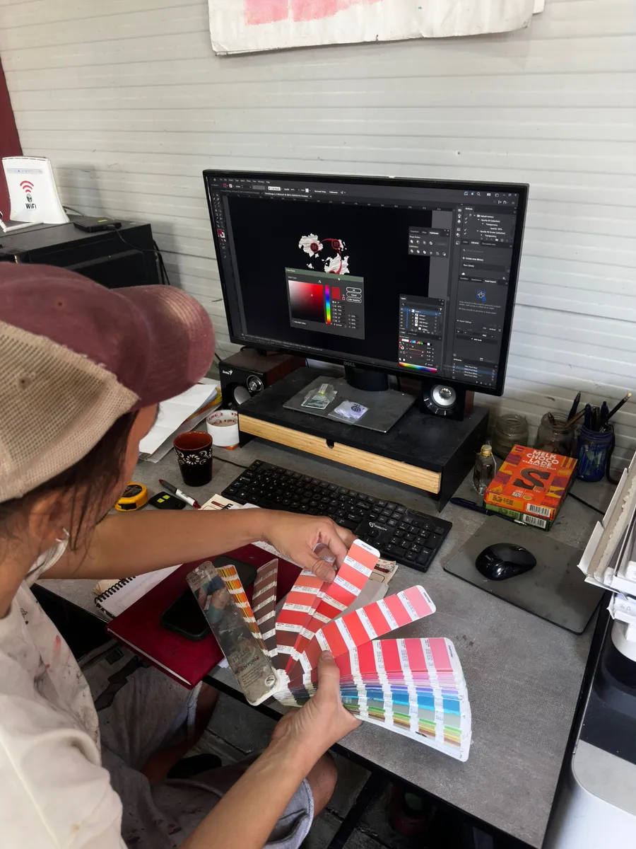 Designer matching ink colours with a Pantone guide before screen printing