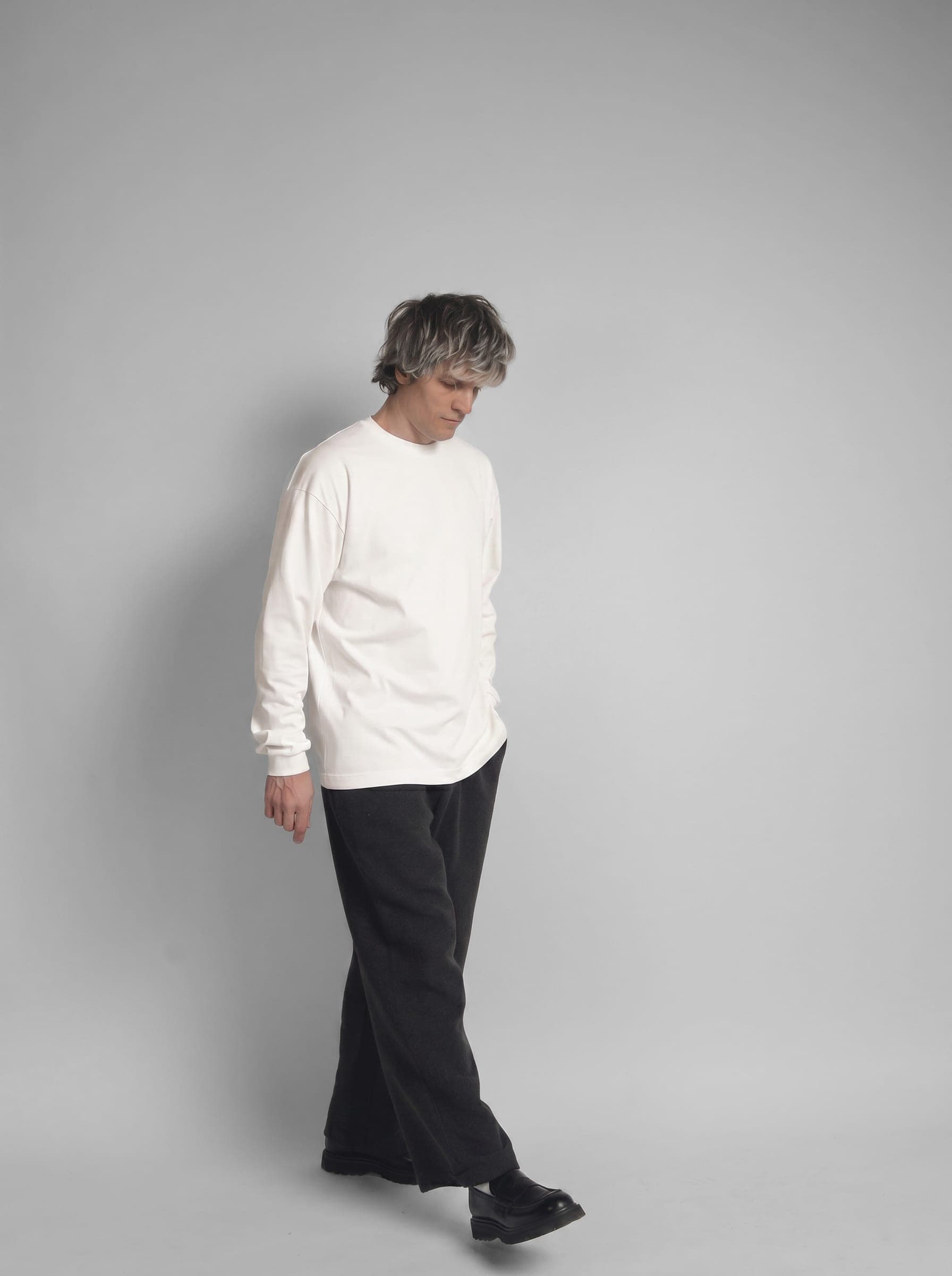 365.APParel Basic Longsleeve Off White — man, full body, three-quarter front view, looking down, studio