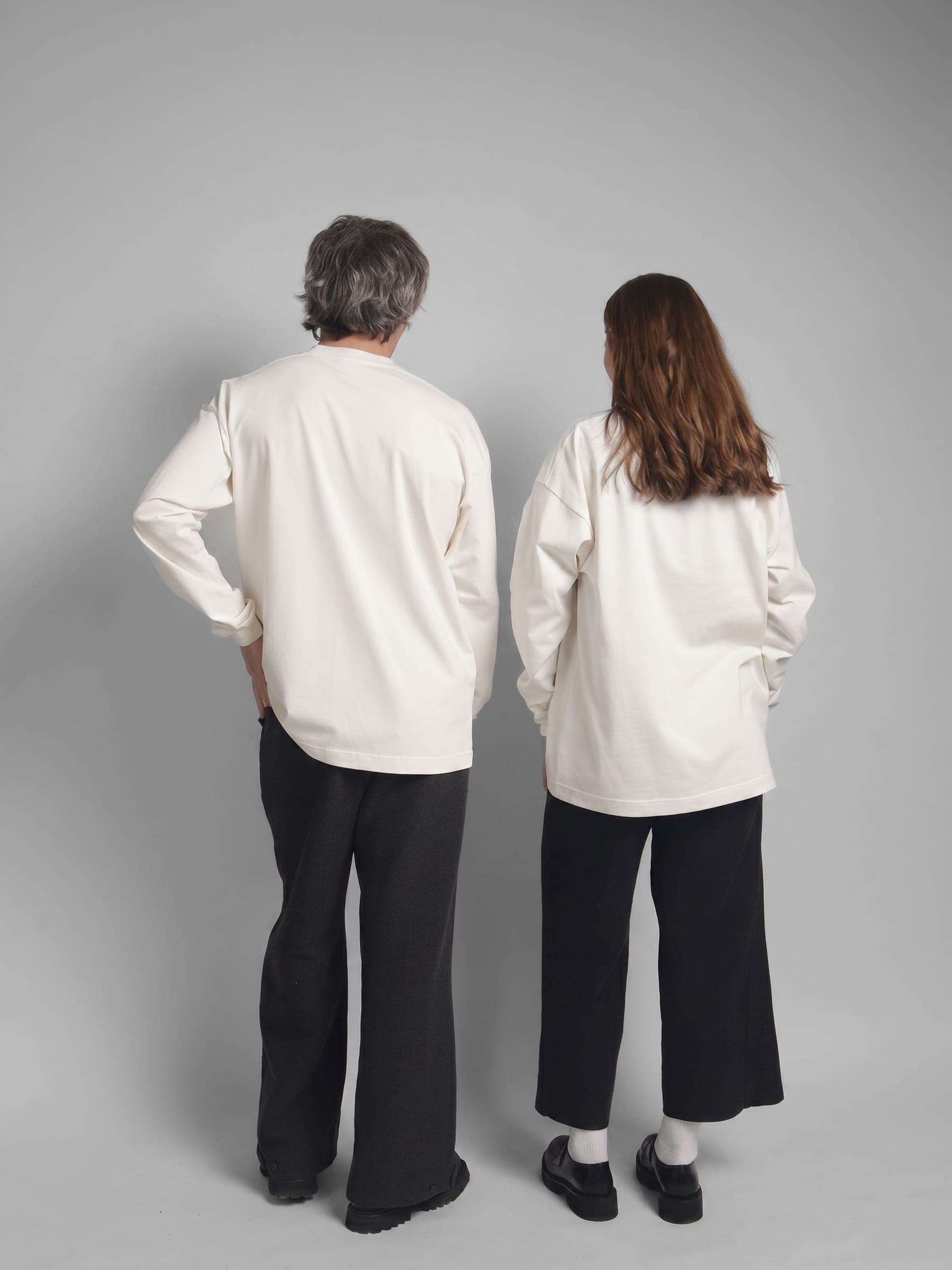 365.APParel Basic Longsleeve Off White — couple in matching basics, full body back view, side by side, studio