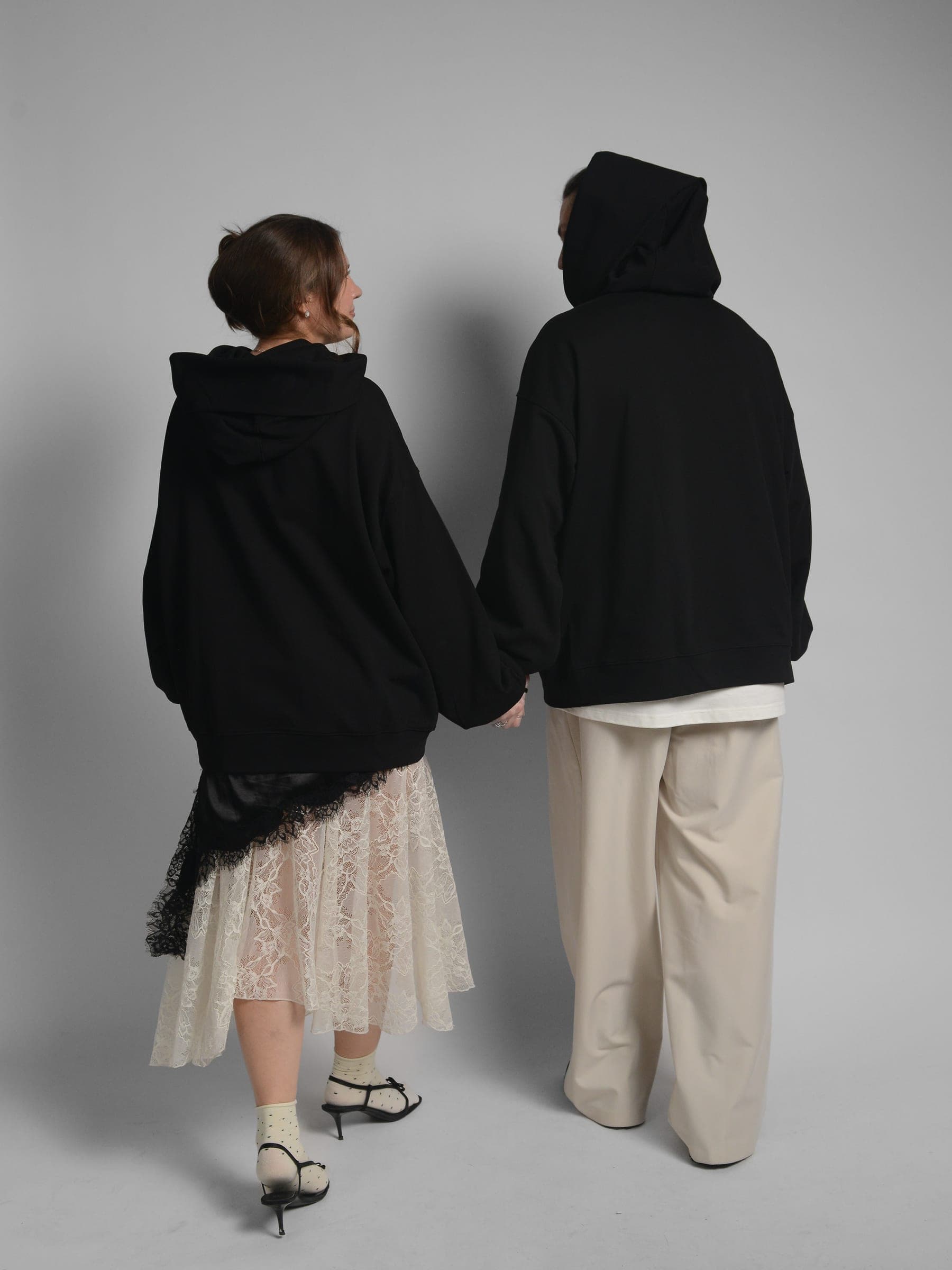 365.APParel Oversize Hoodie Black — couple in matching hoodies, back view, holding hands, hood up, studio