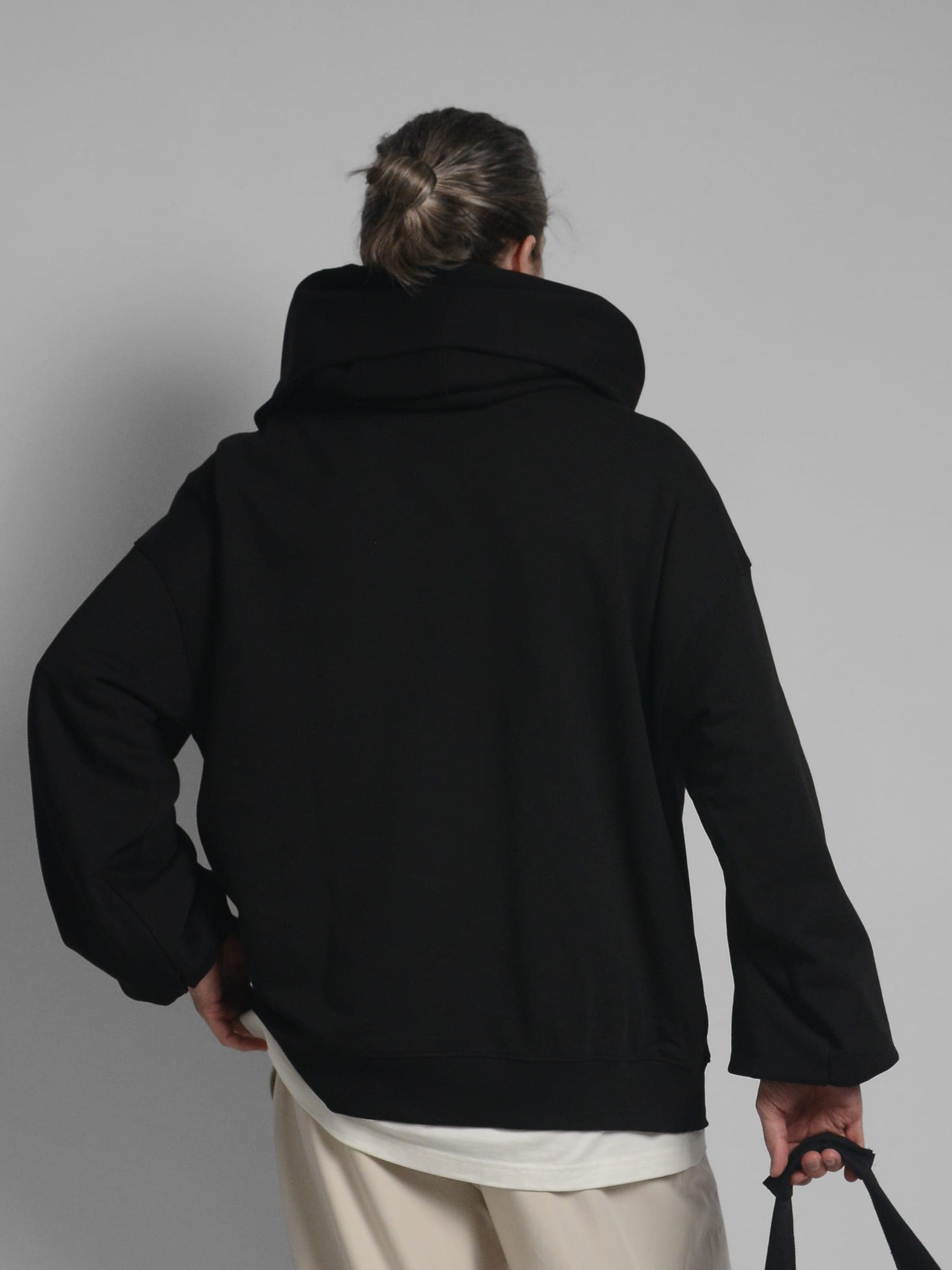 365.APParel Oversize Hoodie Black — man, full body front, low-angle view, glasses, home interior, indoor