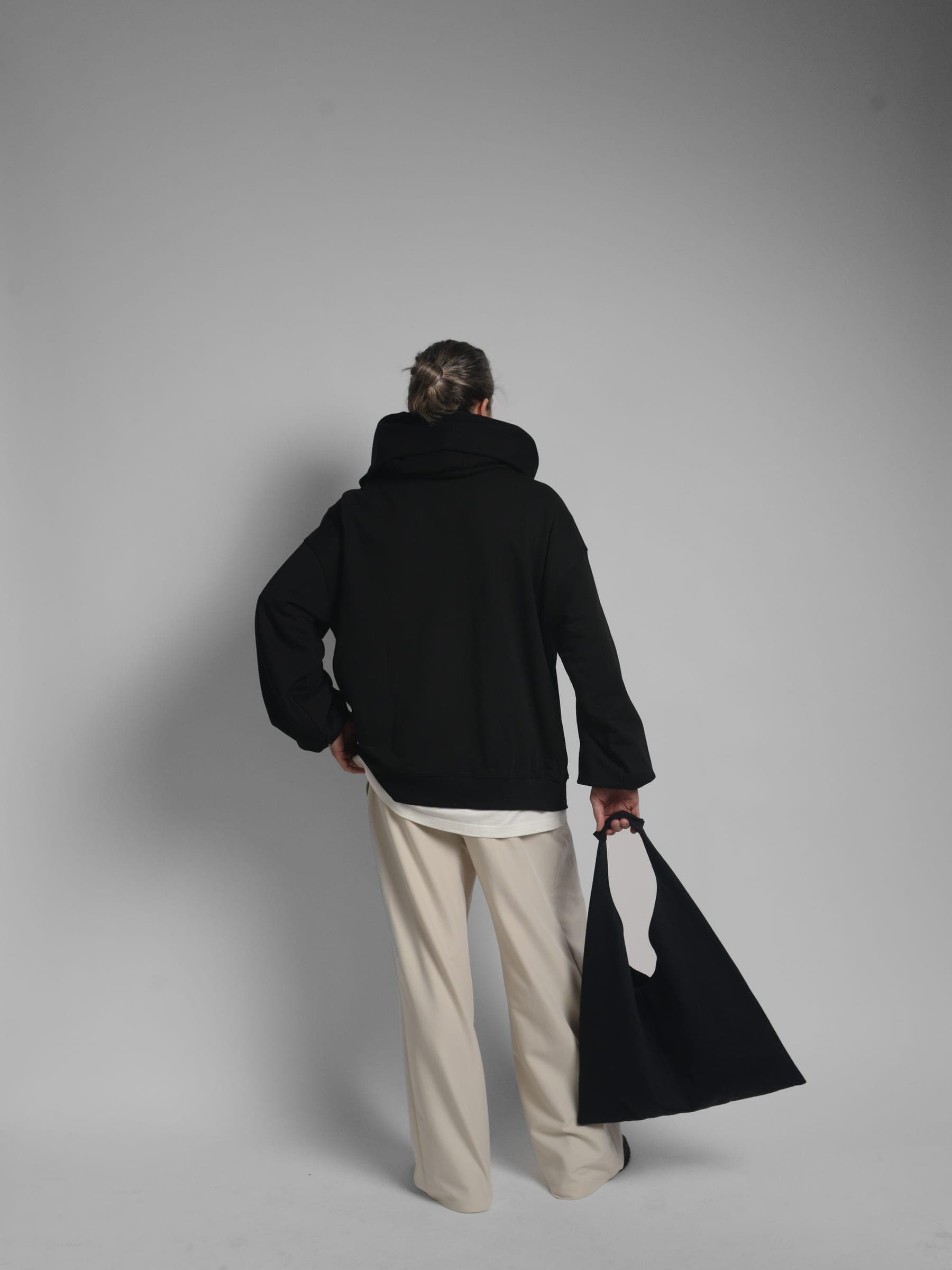 365.APParel Oversize Hoodie Black — man, full body, looking to the side, glasses, home interior, indoor