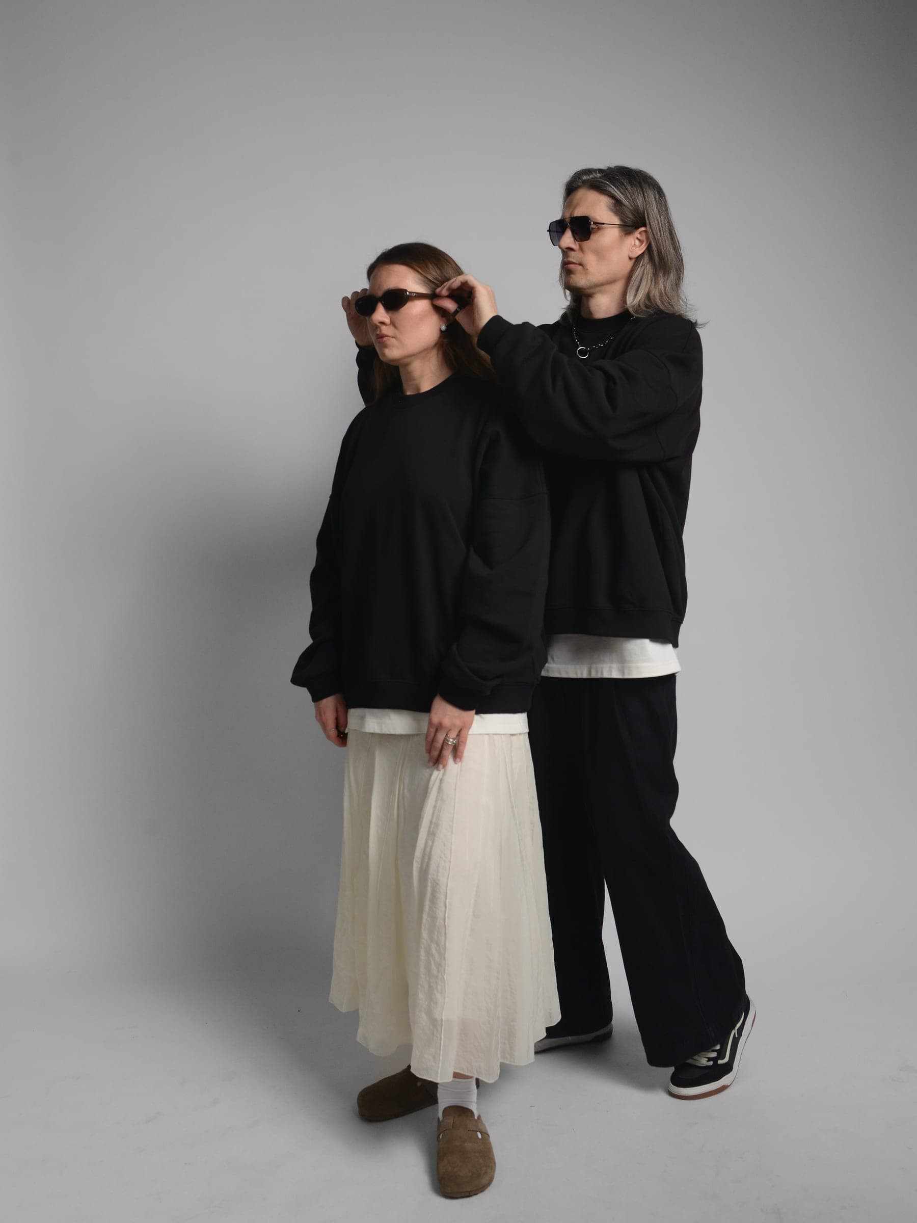 365.APParel Oversize Sweatshirt Black — couple, man adjusting woman's sunglasses, full body front, studio