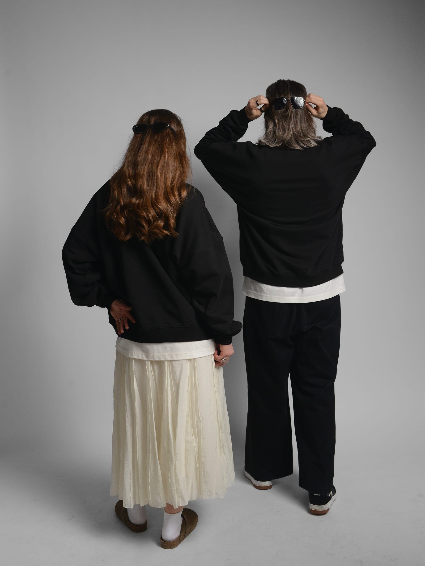 365.APParel Oversize Sweatshirt Black — couple, full body back view, man adjusting sunglasses on head, woman hand on hip, studio