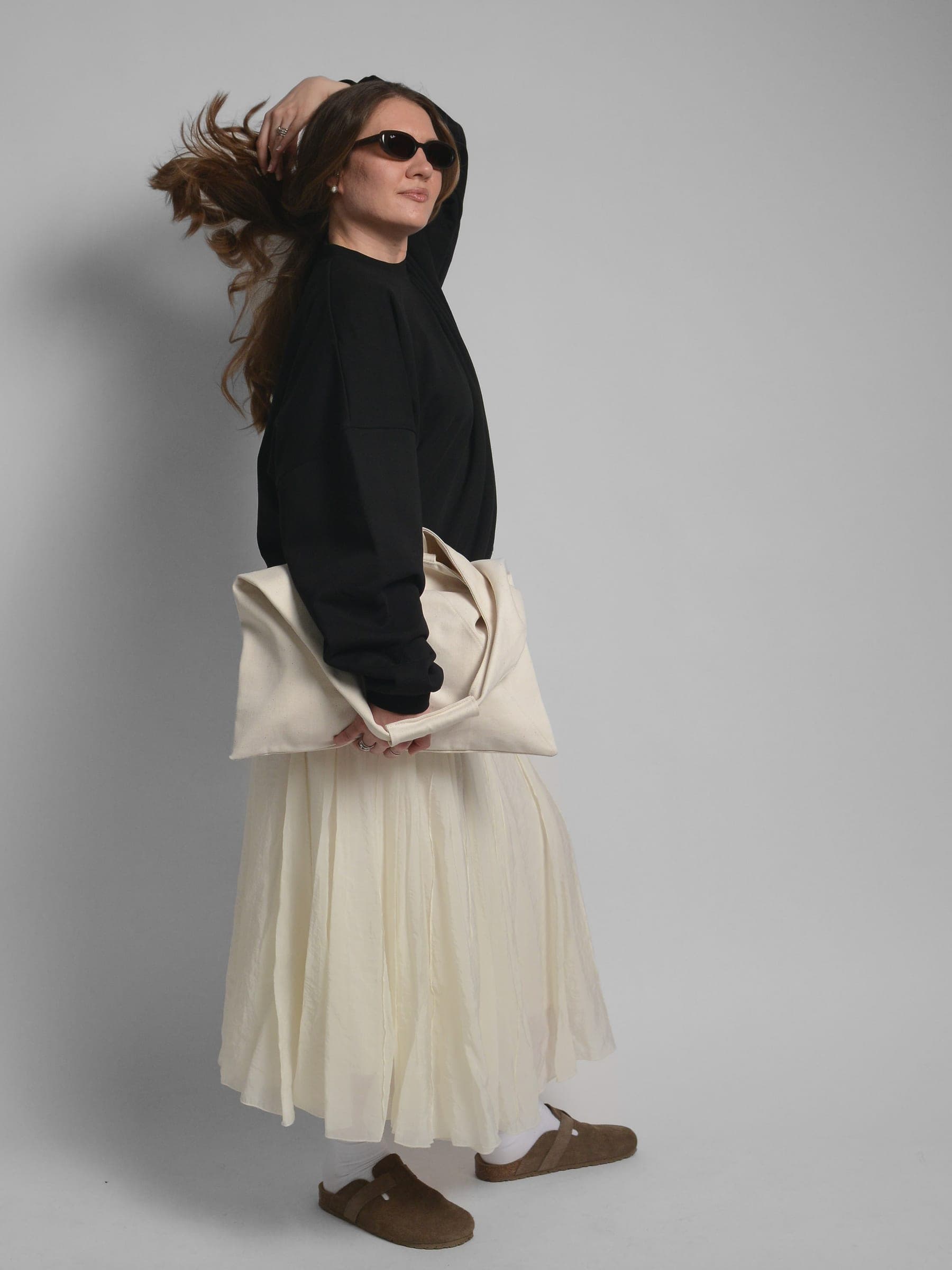 365.APParel Oversize Sweatshirt Black — woman, full body side view, sunglasses, tossing hair, tote bag, studio