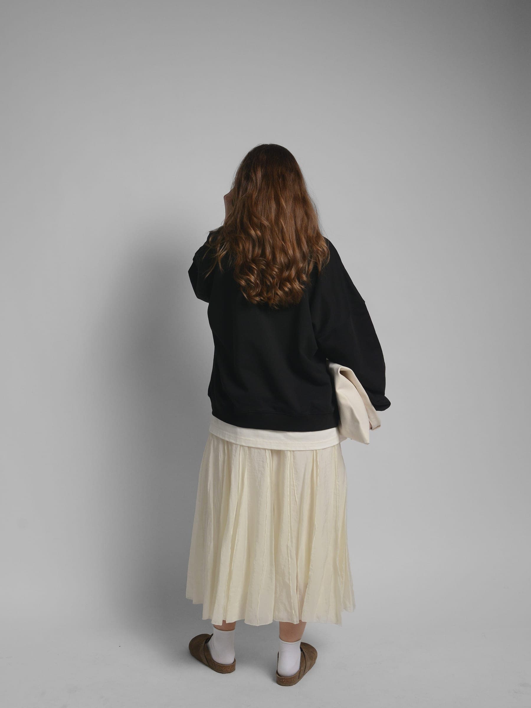 365.APParel Oversize Sweatshirt Black — woman, full body back view, tote bag, pleated maxi skirt, studio