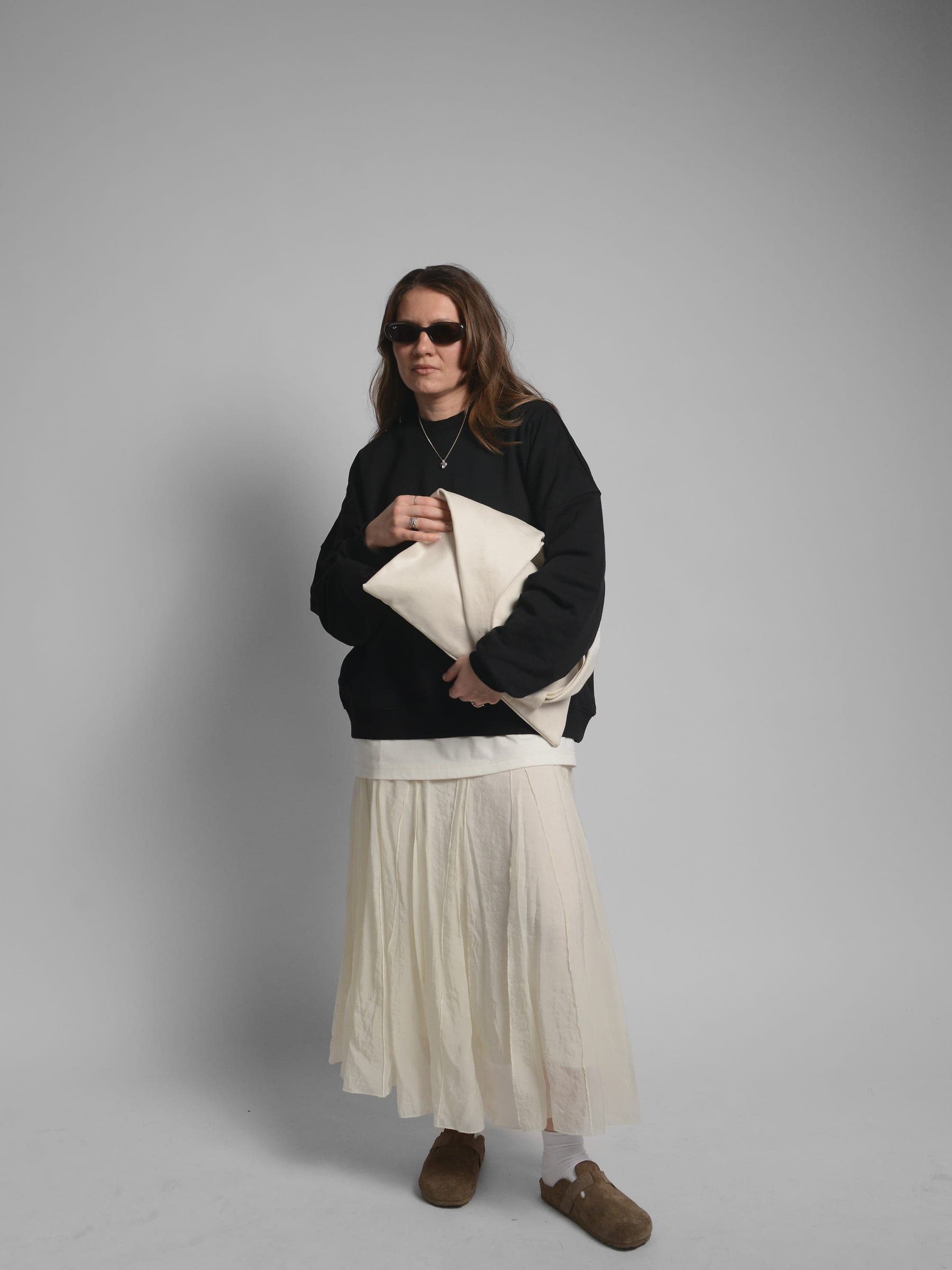 365.APParel Oversize Sweatshirt Black — woman, full body front, sunglasses, holding tote bag, pleated maxi skirt, studio