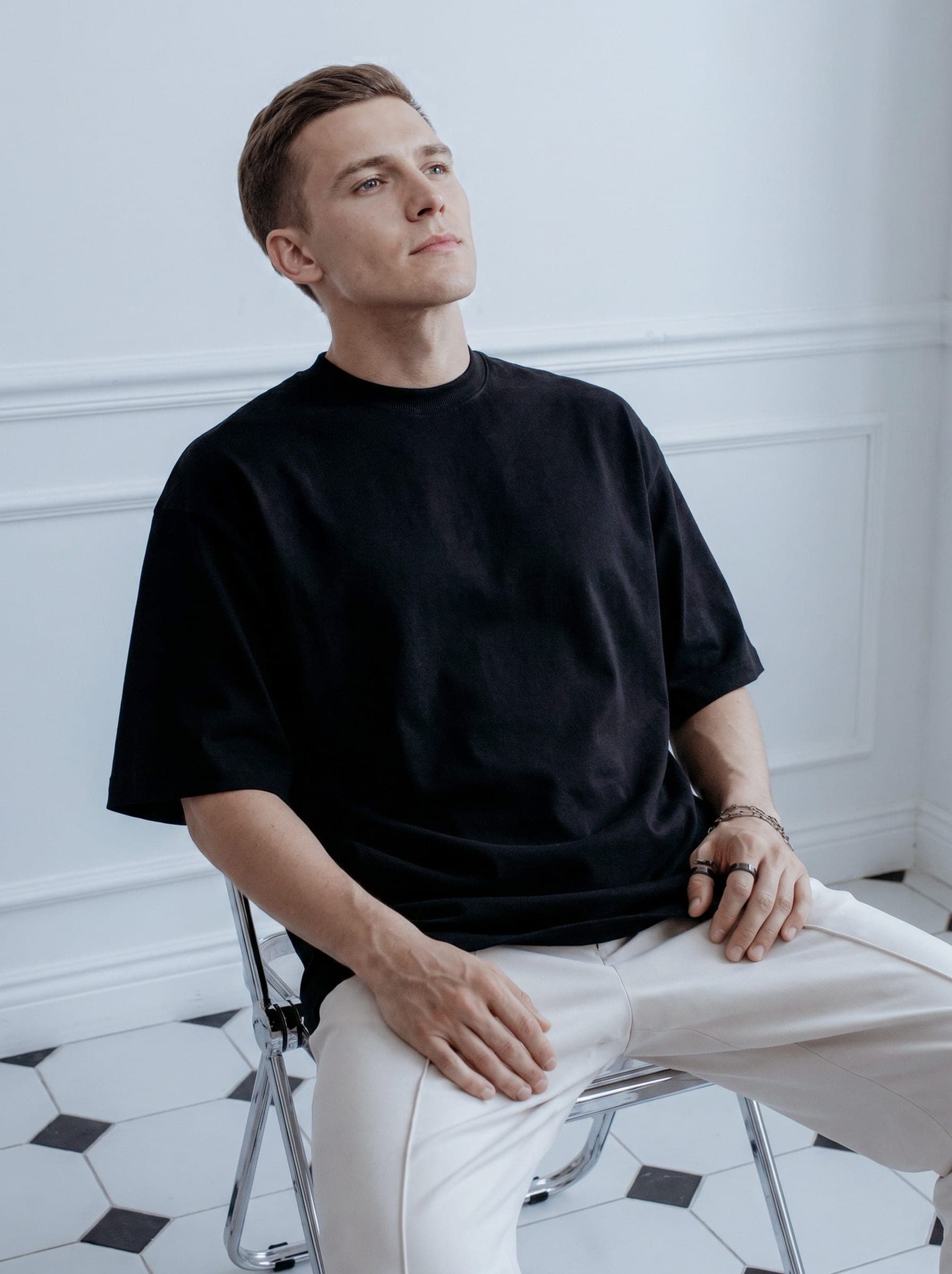 365.APParel Oversize T-shirt Black — man, full body side view, standing, indoor editorial